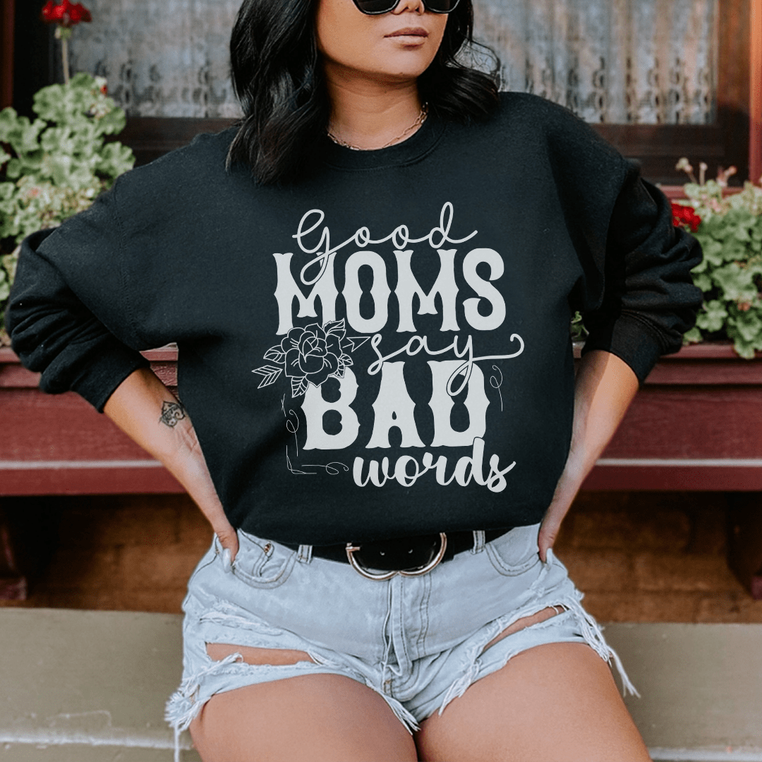 A cozy hoodie featuring the phrase 'Good Moms Say Bad Words', designed by top artists, made from a cotton/poly fleece blend.