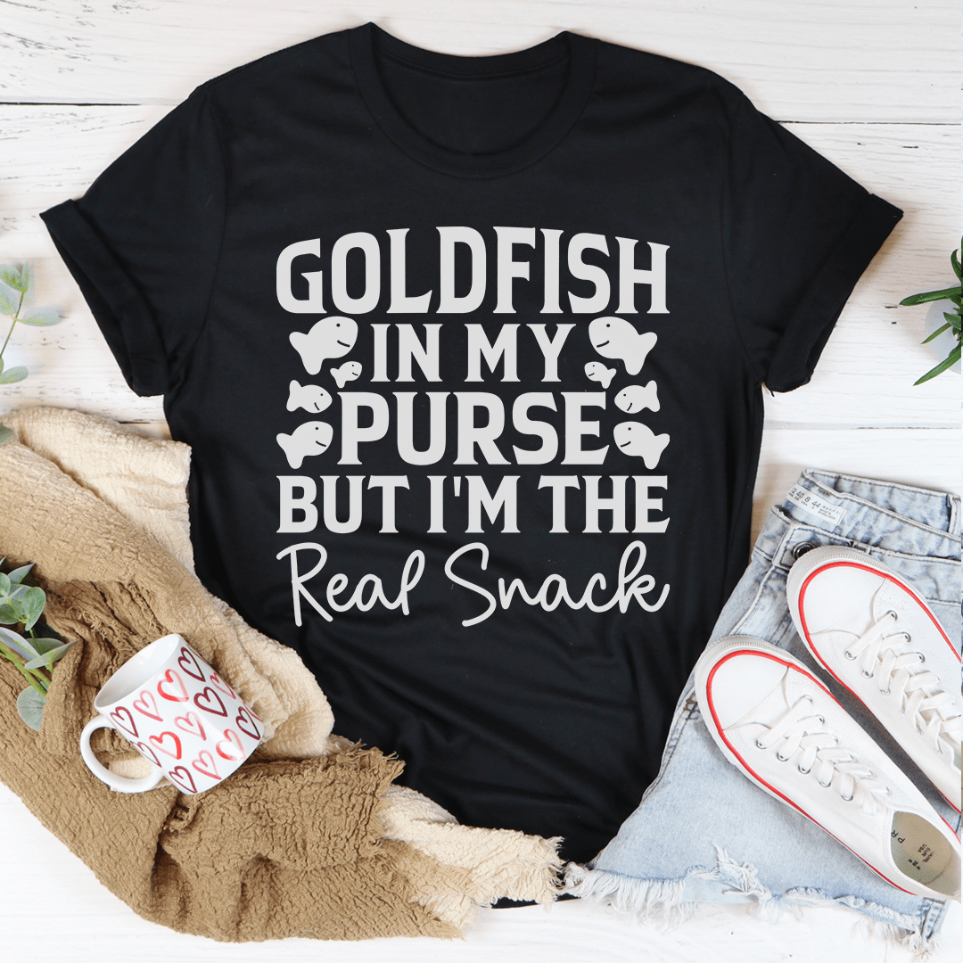 A stylish t-shirt featuring the phrase 'Goldfish In My Purse But I'm The Real Snack' in a playful design, made from soft cotton.