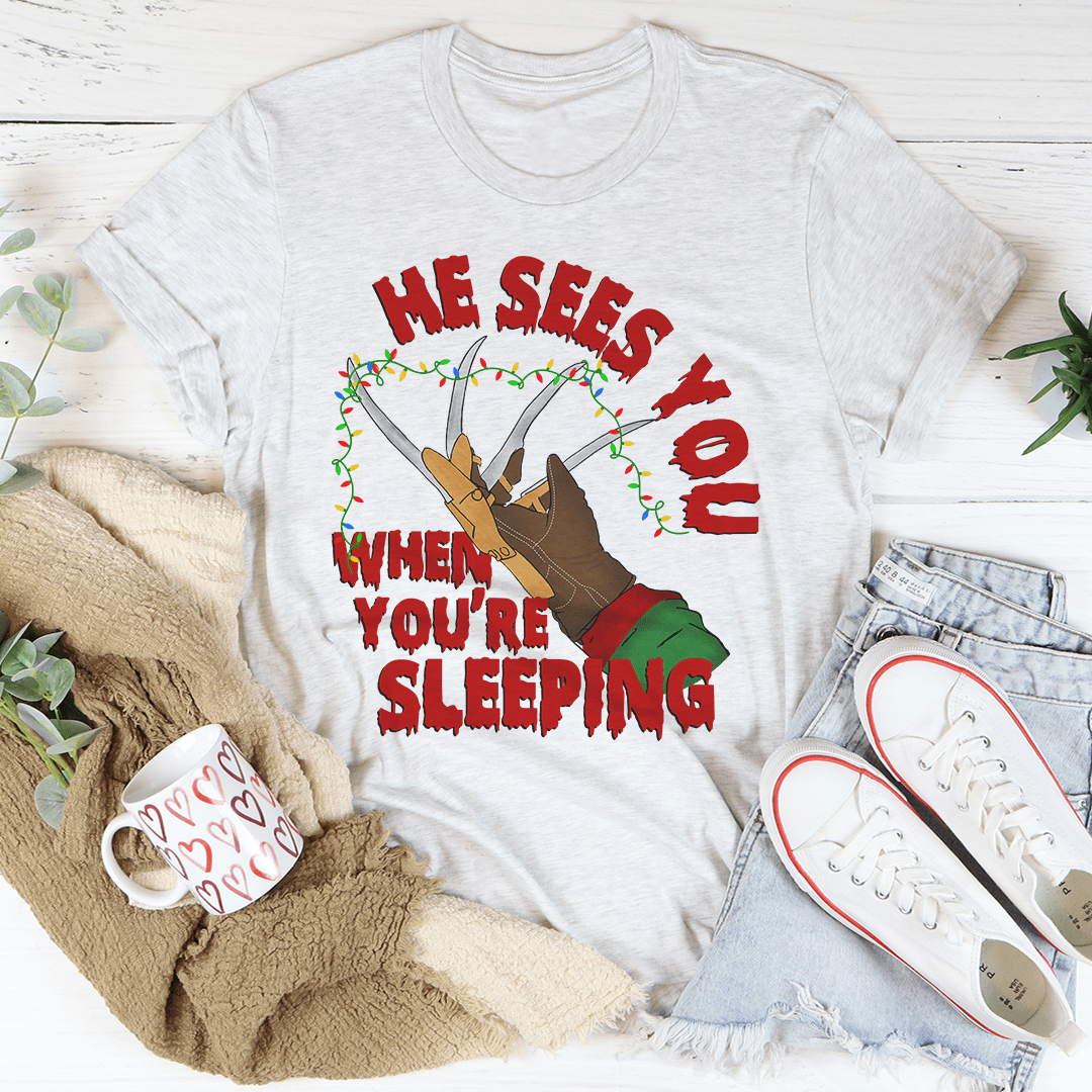 He Sees You When You're Sleeping T-Shirt featuring a whimsical design, made from soft ring-spun cotton with double stitching for durability.