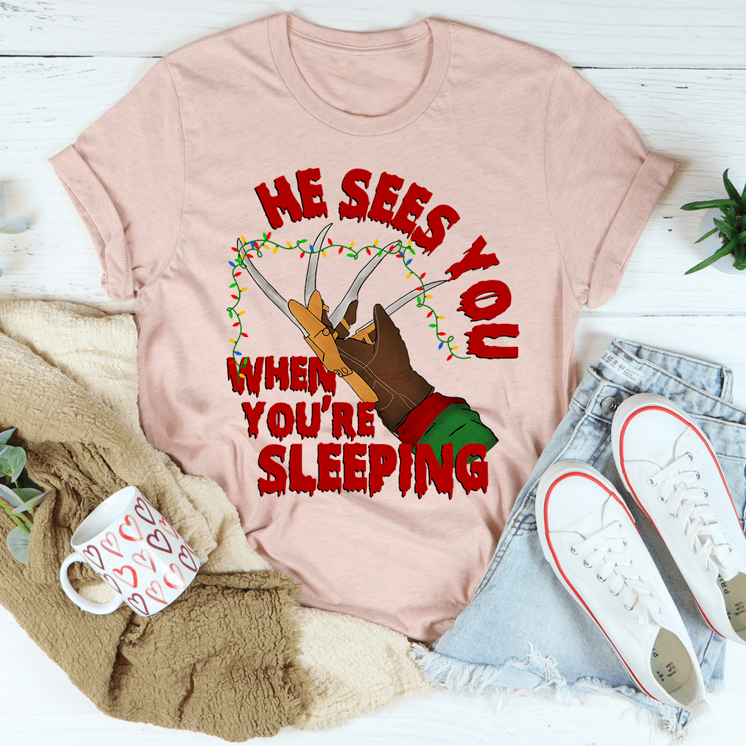 He Sees You When You're Sleeping T-Shirt featuring a whimsical design, made from soft ring-spun cotton with double stitching for durability.