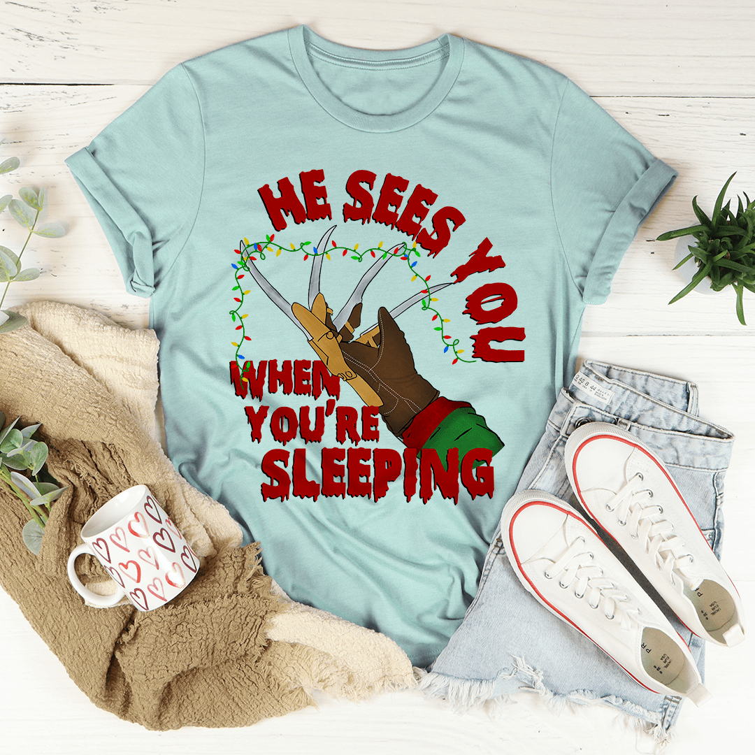 He Sees You When You're Sleeping T-Shirt featuring a whimsical design, made from soft ring-spun cotton with double stitching for durability.