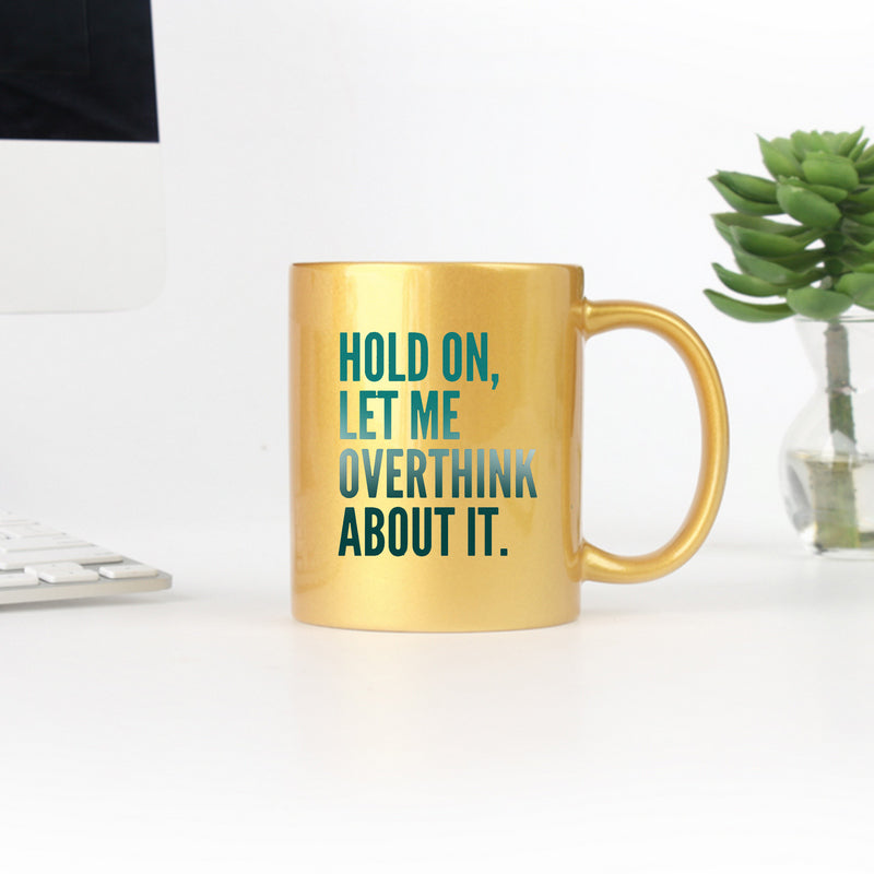 Elegant gold and silver ceramic mug with the phrase 'Hold On Let Me Overthink About It' designed for stylish beverage enjoyment.