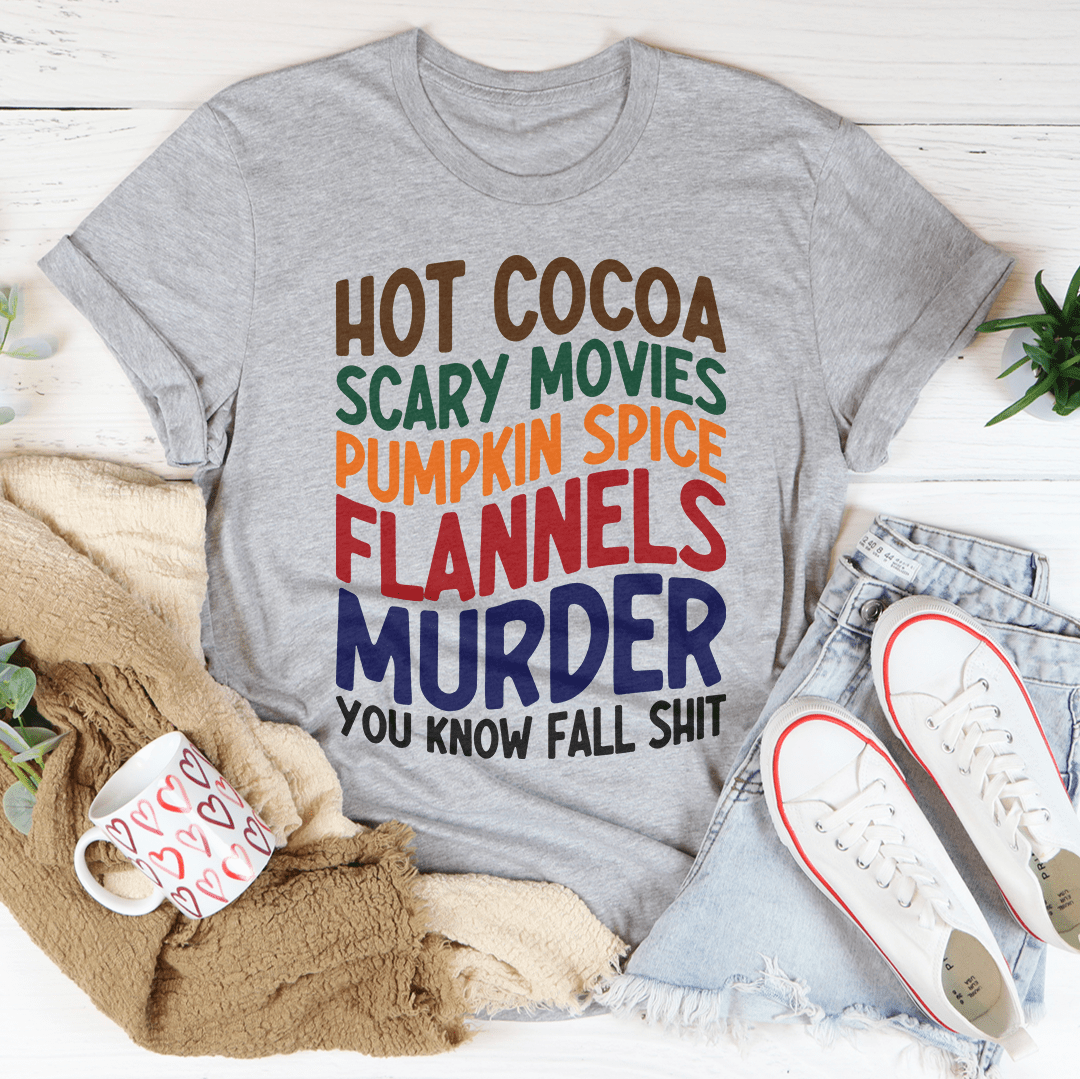 A cozy t-shirt featuring a fun design with hot cocoa, scary movies, and pumpkin spice themes, perfect for fall.