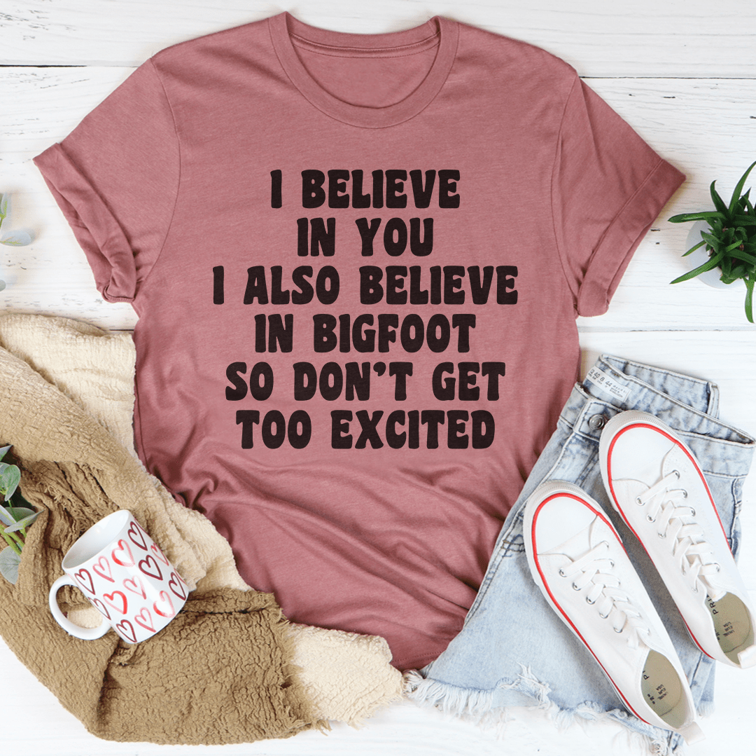 A comfortable t-shirt featuring the phrase 'I Believe In You I Also Believe In Bigfoot', made from soft cotton with double stitching.