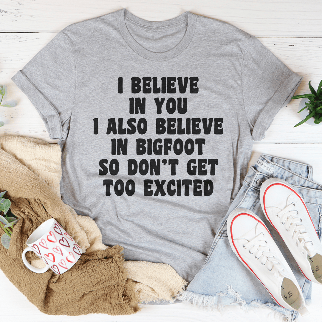 A comfortable t-shirt featuring the phrase 'I Believe In You I Also Believe In Bigfoot', made from soft cotton with double stitching.