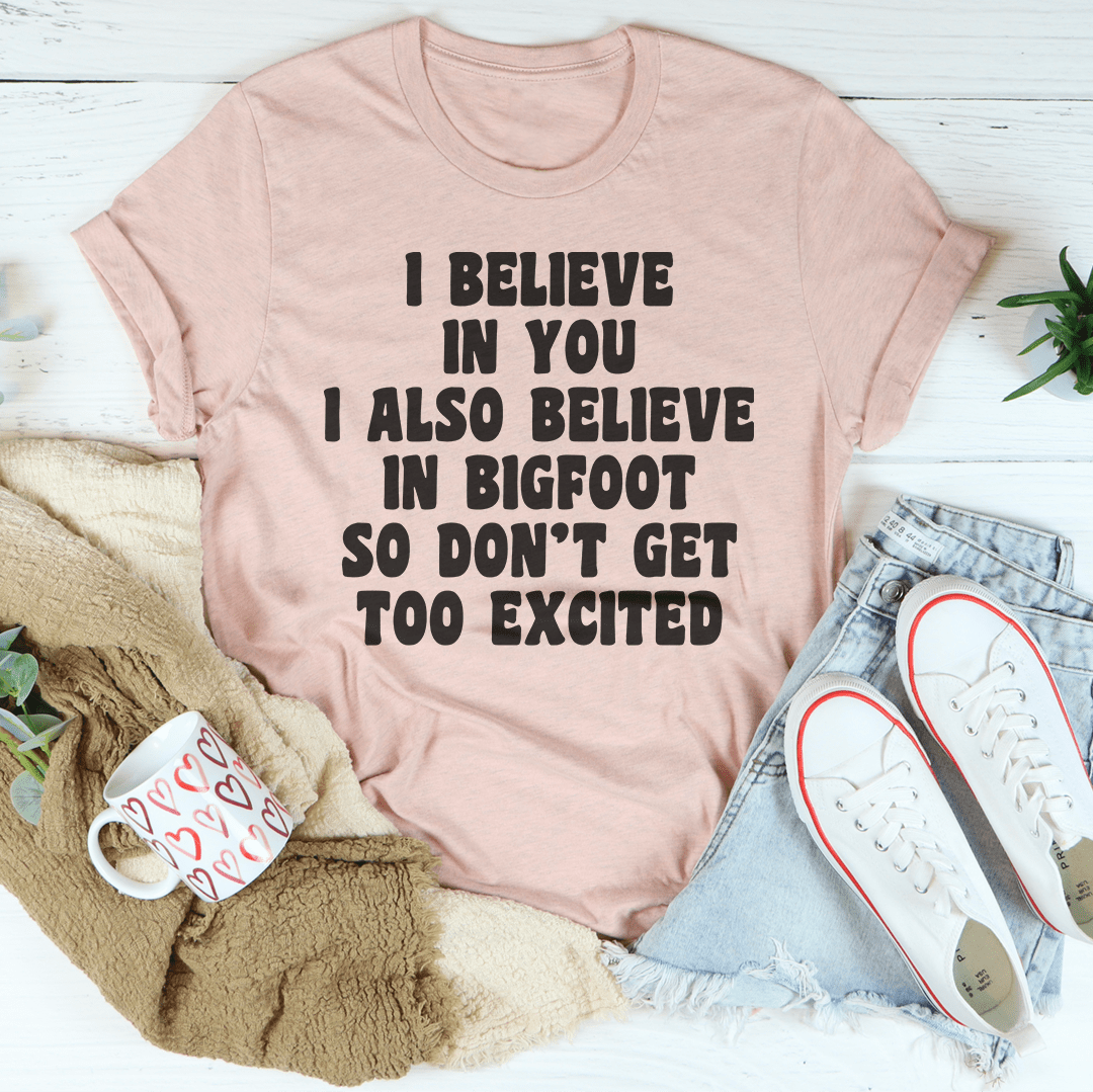 A comfortable t-shirt featuring the phrase 'I Believe In You I Also Believe In Bigfoot', made from soft cotton with double stitching.