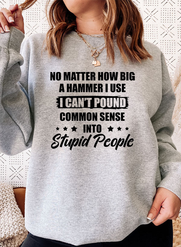 A cozy sweatshirt featuring the phrase 'I Can't Pound Common Sense Into Stupid People' in bold lettering, perfect for casual wear.