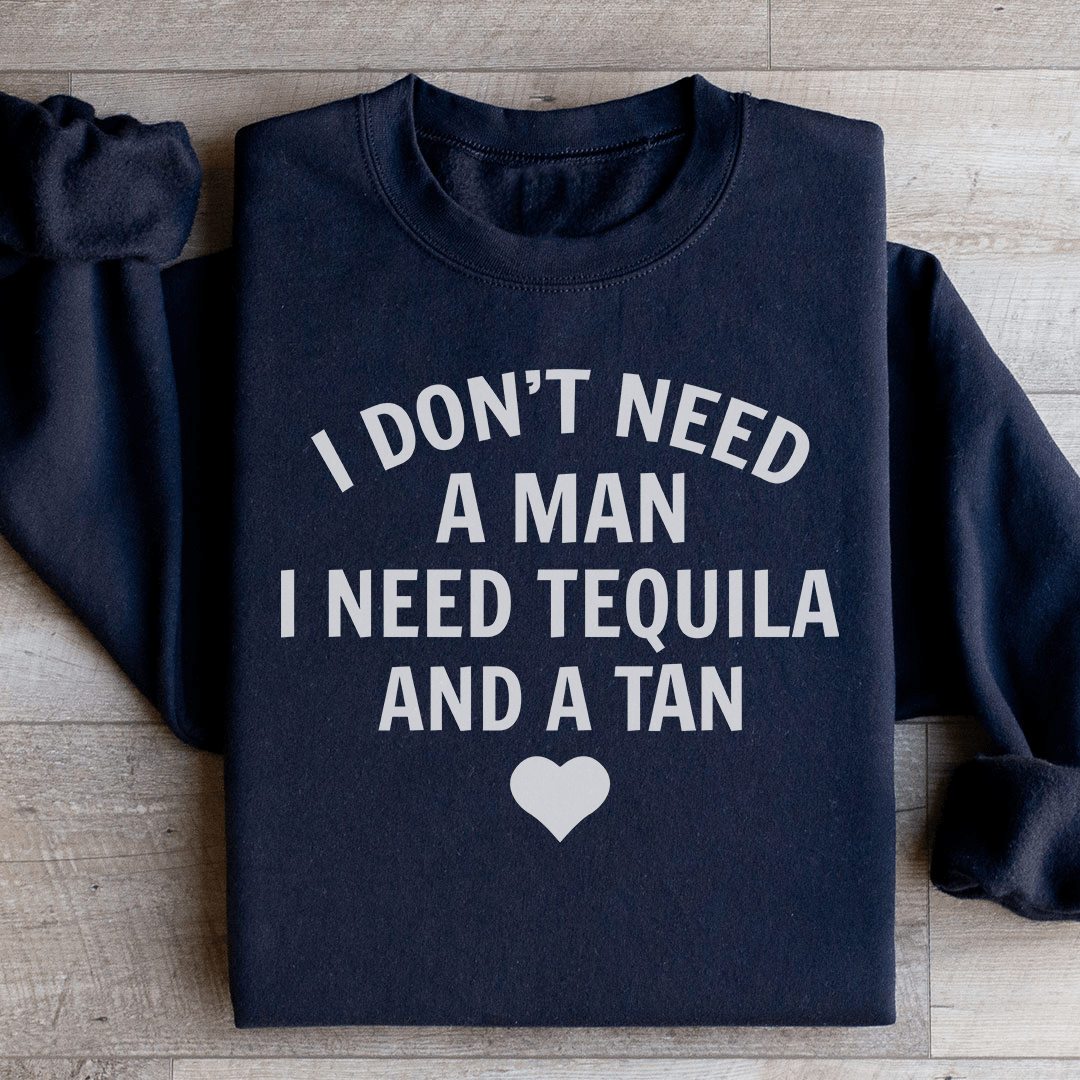 A cozy hoodie featuring the phrase 'I Don't Need A Man I Need Tequila And A Tan', perfect for casual wear.