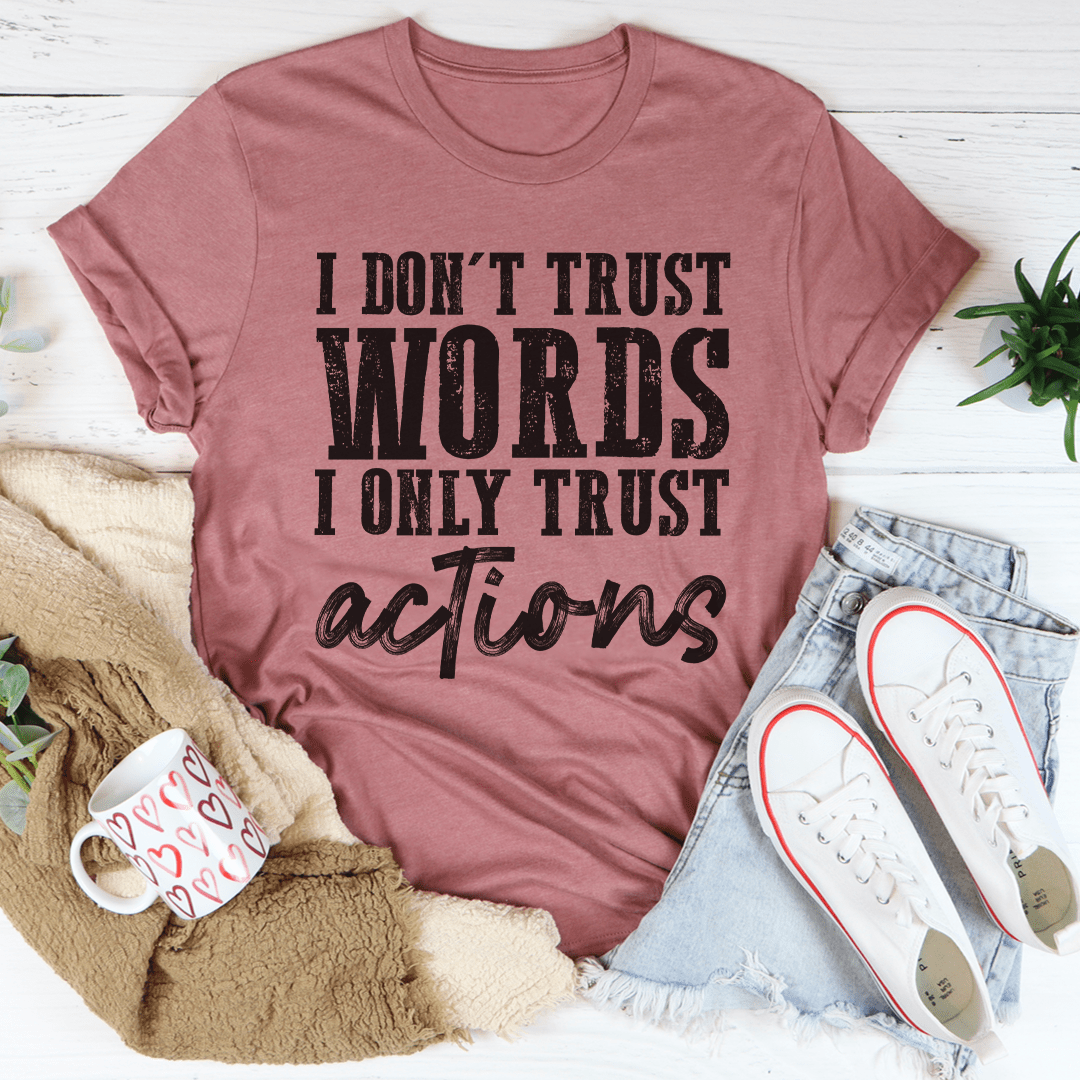 A black t-shirt featuring the phrase 'I Don't Trust Words I Only Trust Actions' printed in bold white letters, showcasing its soft cotton fabric and durable stitching.