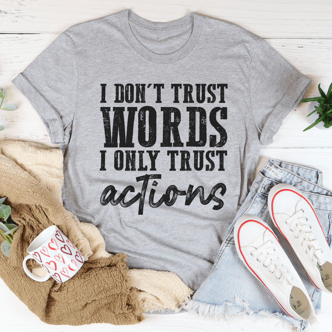 A black t-shirt featuring the phrase 'I Don't Trust Words I Only Trust Actions' printed in bold white letters, showcasing its soft cotton fabric and durable stitching.