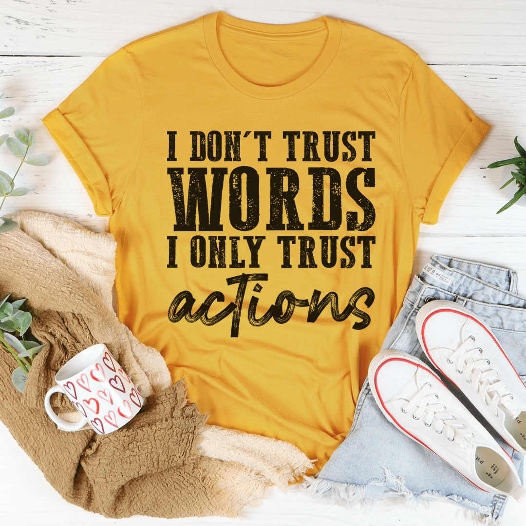 A black t-shirt featuring the phrase 'I Don't Trust Words I Only Trust Actions' printed in bold white letters, showcasing its soft cotton fabric and durable stitching.