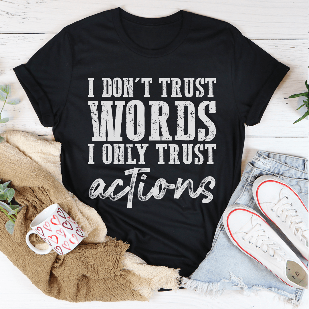 A black t-shirt featuring the phrase 'I Don't Trust Words I Only Trust Actions' printed in bold white letters, showcasing its soft cotton fabric and durable stitching.