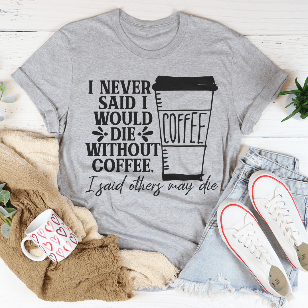 A stylish black t-shirt with the phrase 'I Never Said I Would Die Without Coffee' printed in white, showcasing its soft fabric and durable stitching.