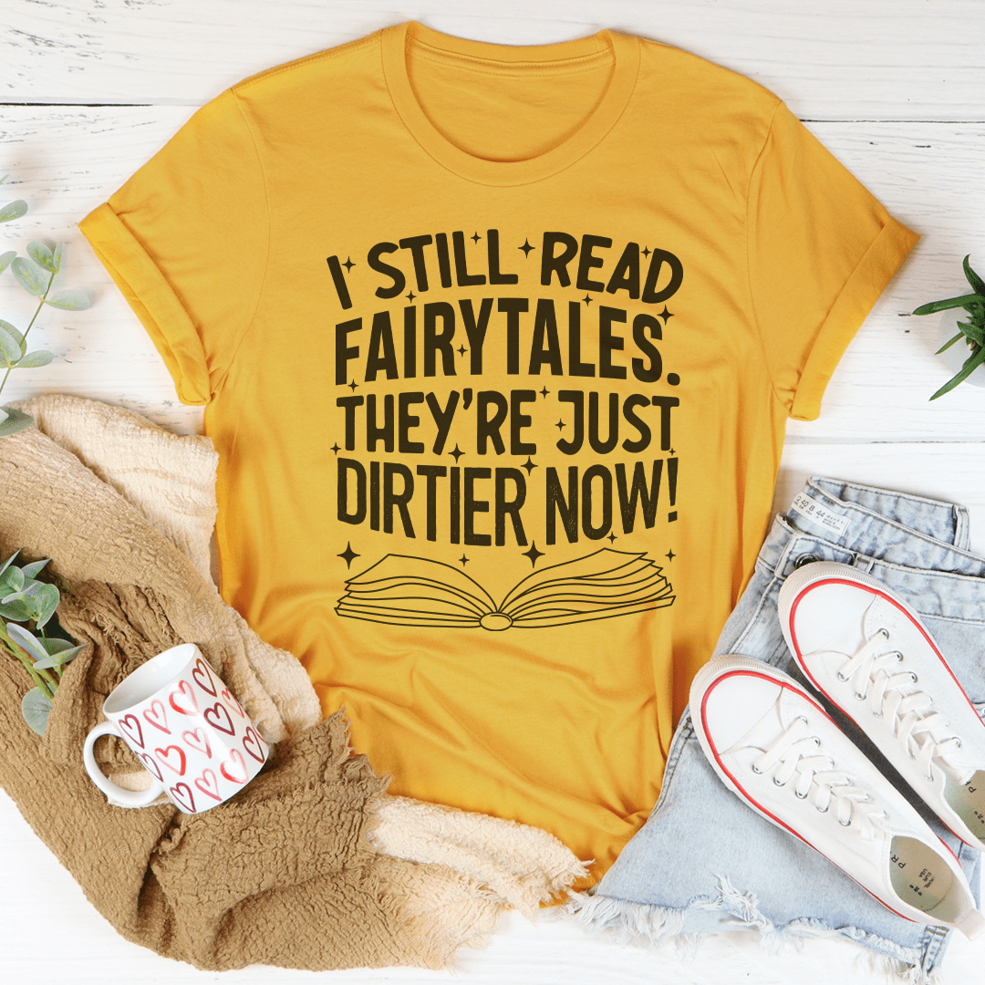 A stylish black t-shirt featuring the phrase 'I Still Read Fairytales They're Just Dirtier Now' in playful typography, showcasing its comfortable fit and quality fabric.