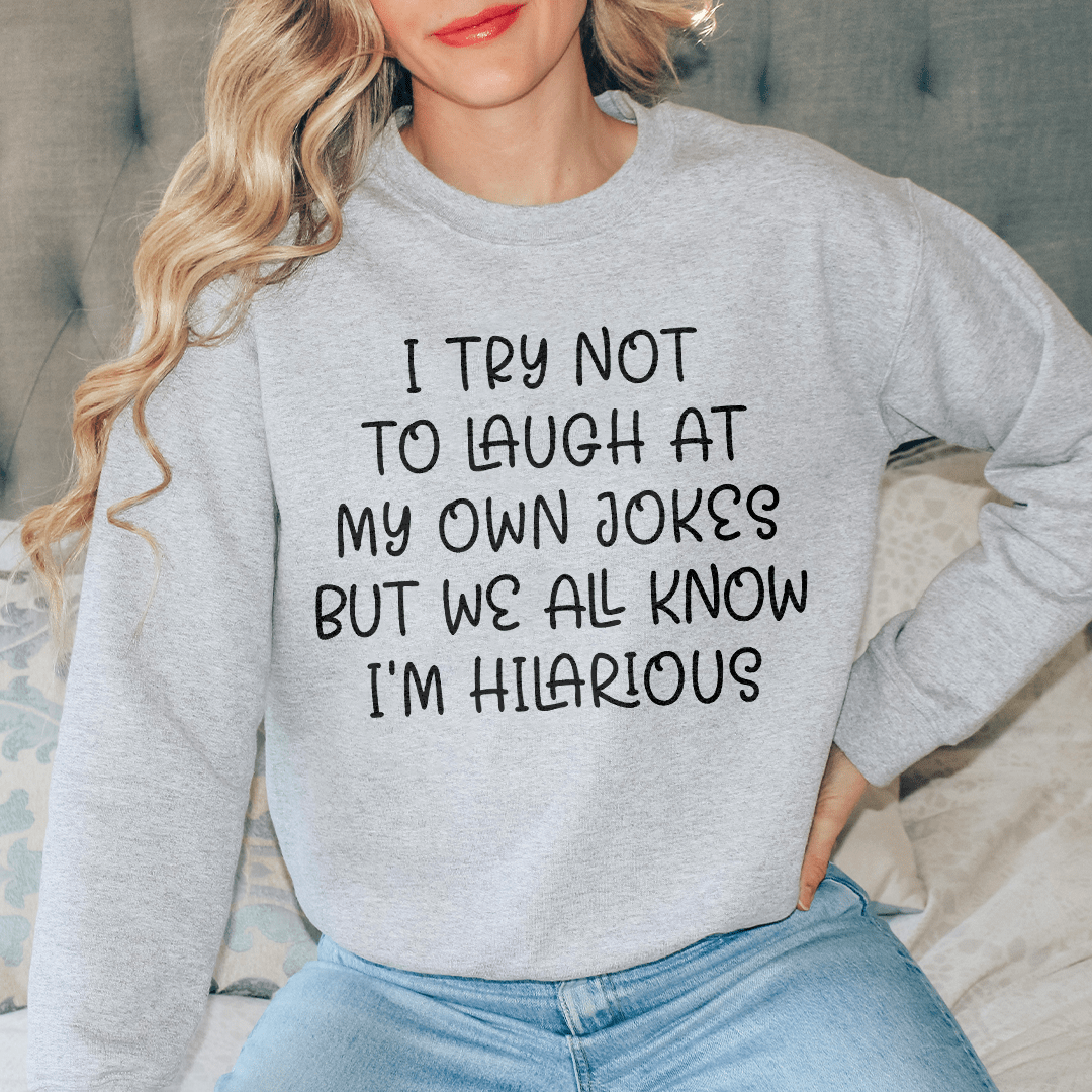 Cozy sweatshirt featuring the phrase 'I Try Not To Laugh At My Own Jokes', designed by top artists, showcasing a stylish and humorous design.