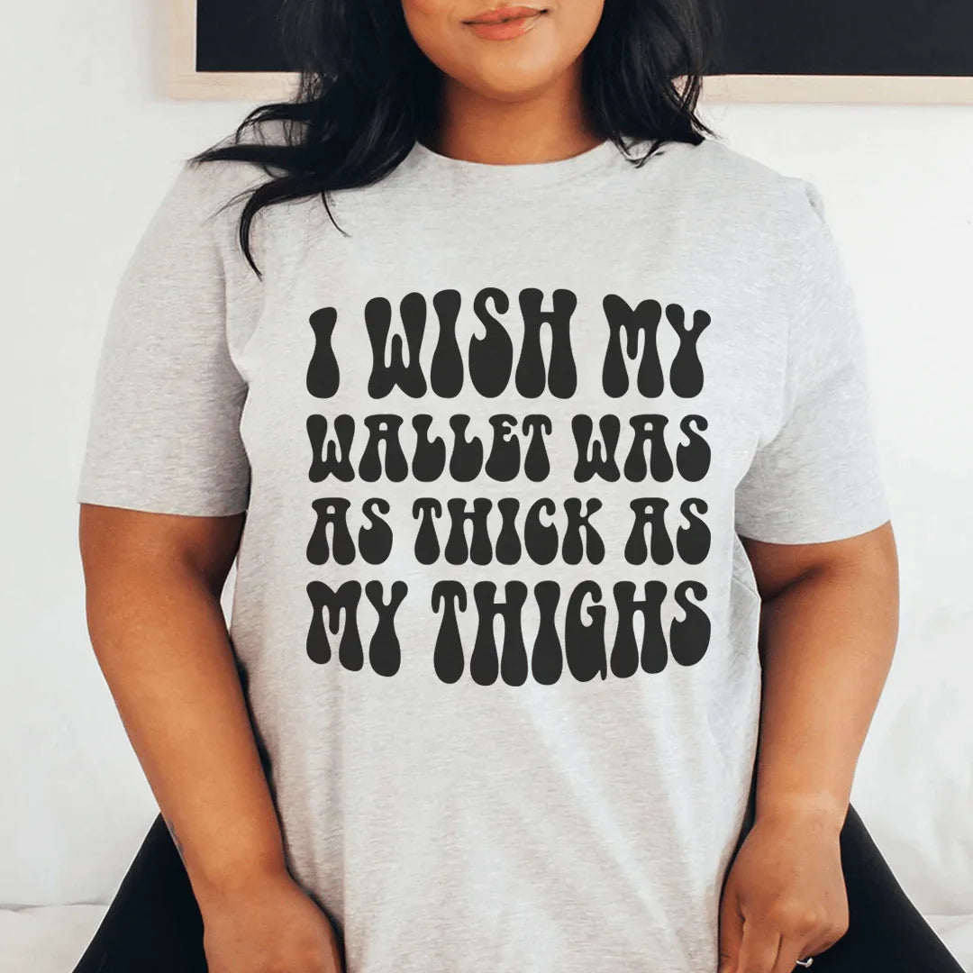 A stylish t-shirt featuring the phrase 'I Wish My Wallet Has As Thick As My Thighs' printed on soft, durable cotton fabric.