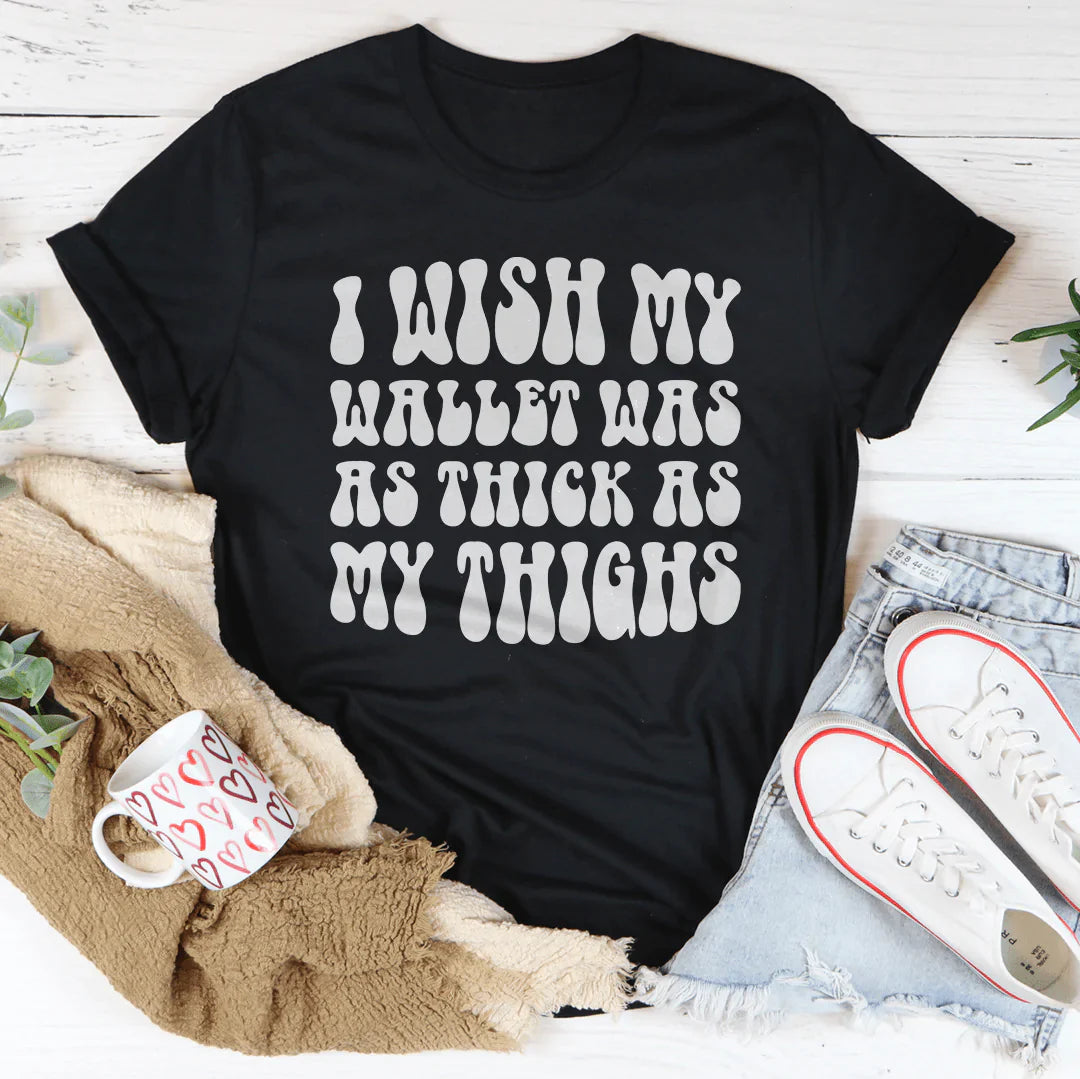 A stylish t-shirt featuring the phrase 'I Wish My Wallet Has As Thick As My Thighs' printed on soft, durable cotton fabric.