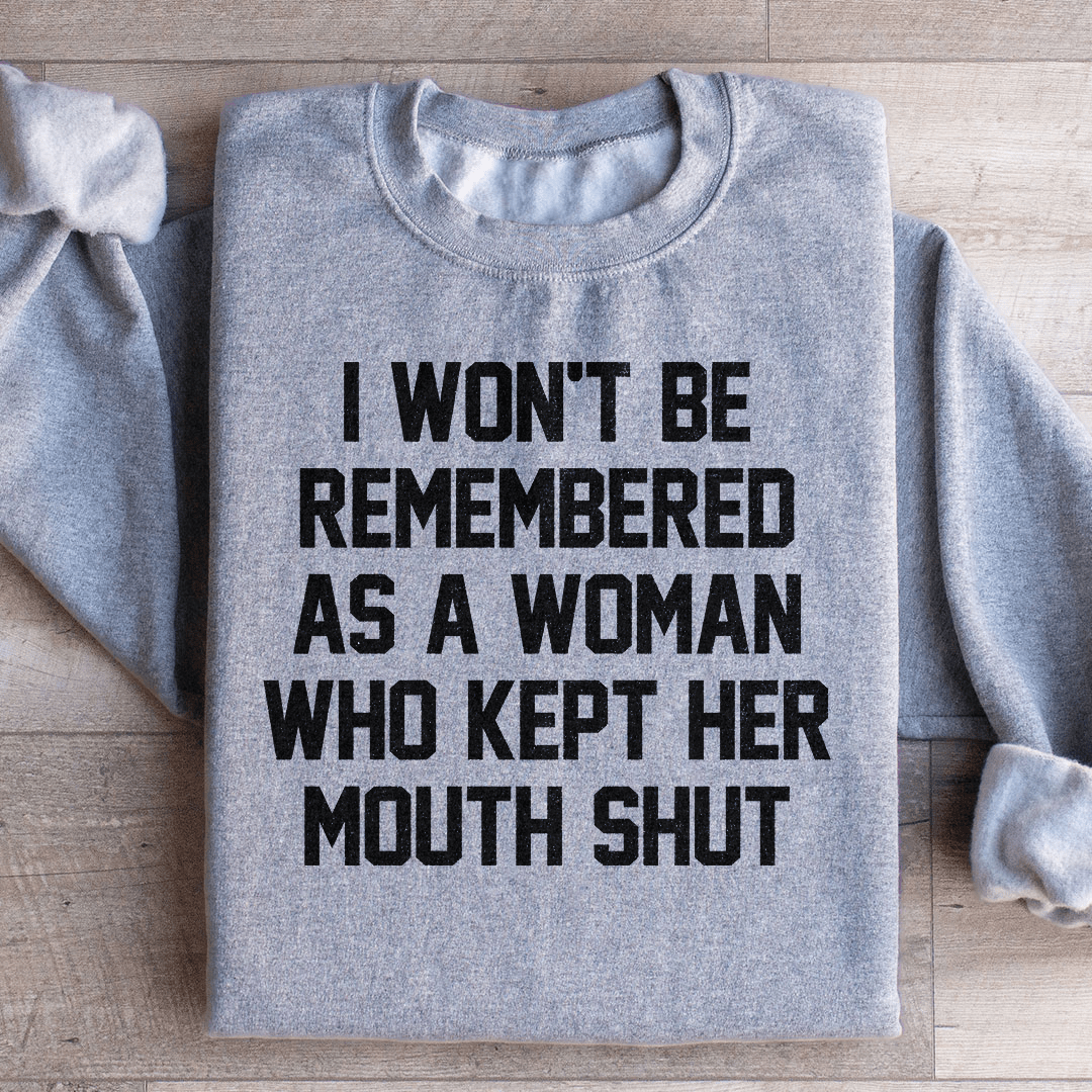 A stylish sweatshirt featuring the phrase 'I Won't Be Remembered As A Woman Who Kept Her Mouth', designed by top artists, showcasing a cozy fleece material.