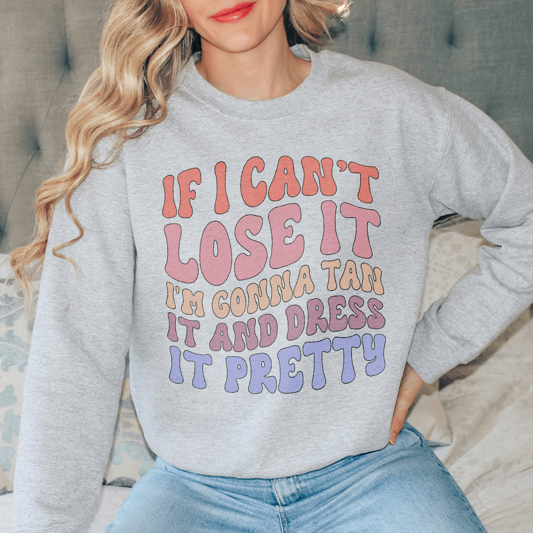 A cozy hoodie featuring the phrase 'If I Can't Lose It I'm Gonna Tan It And Dress It Pretty', designed by top artists, showcasing vibrant colors and a comfortable fit.