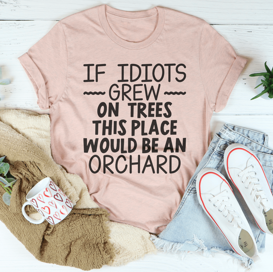 A humorous t-shirt featuring the phrase 'If Idiots Grew On Trees This Place Would Be An Orchard' printed on soft cotton fabric.