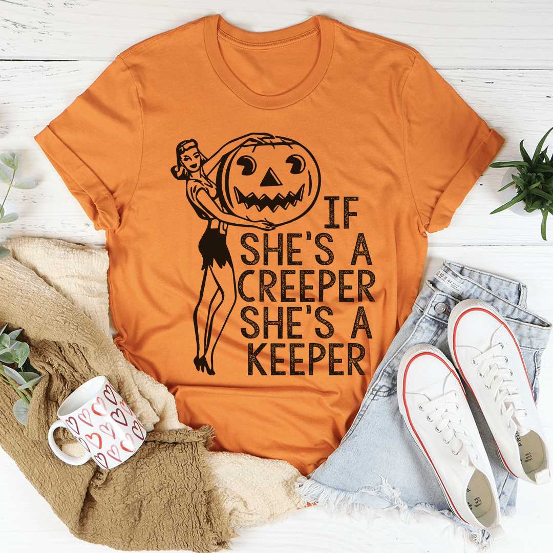 A stylish t-shirt featuring the phrase 'If She's A Creeper She's A Keeper' printed on soft cotton fabric, showcasing its durability and comfort.