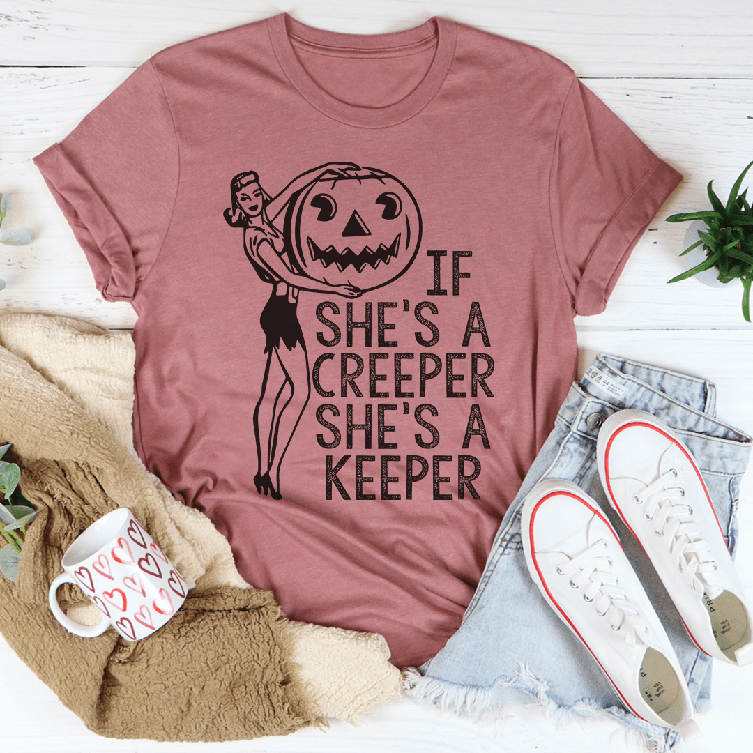 A stylish t-shirt featuring the phrase 'If She's A Creeper She's A Keeper' printed on soft cotton fabric, showcasing its durability and comfort.