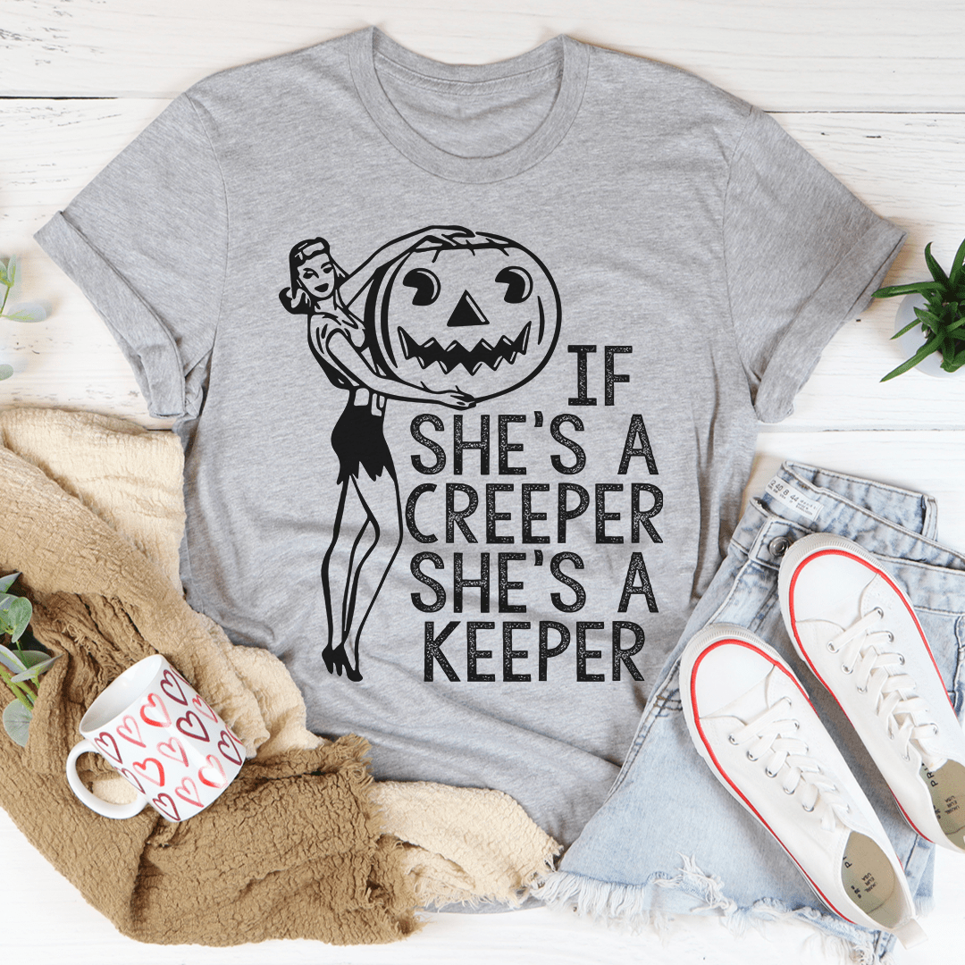 A stylish t-shirt featuring the phrase 'If She's A Creeper She's A Keeper' printed on soft cotton fabric, showcasing its durability and comfort.