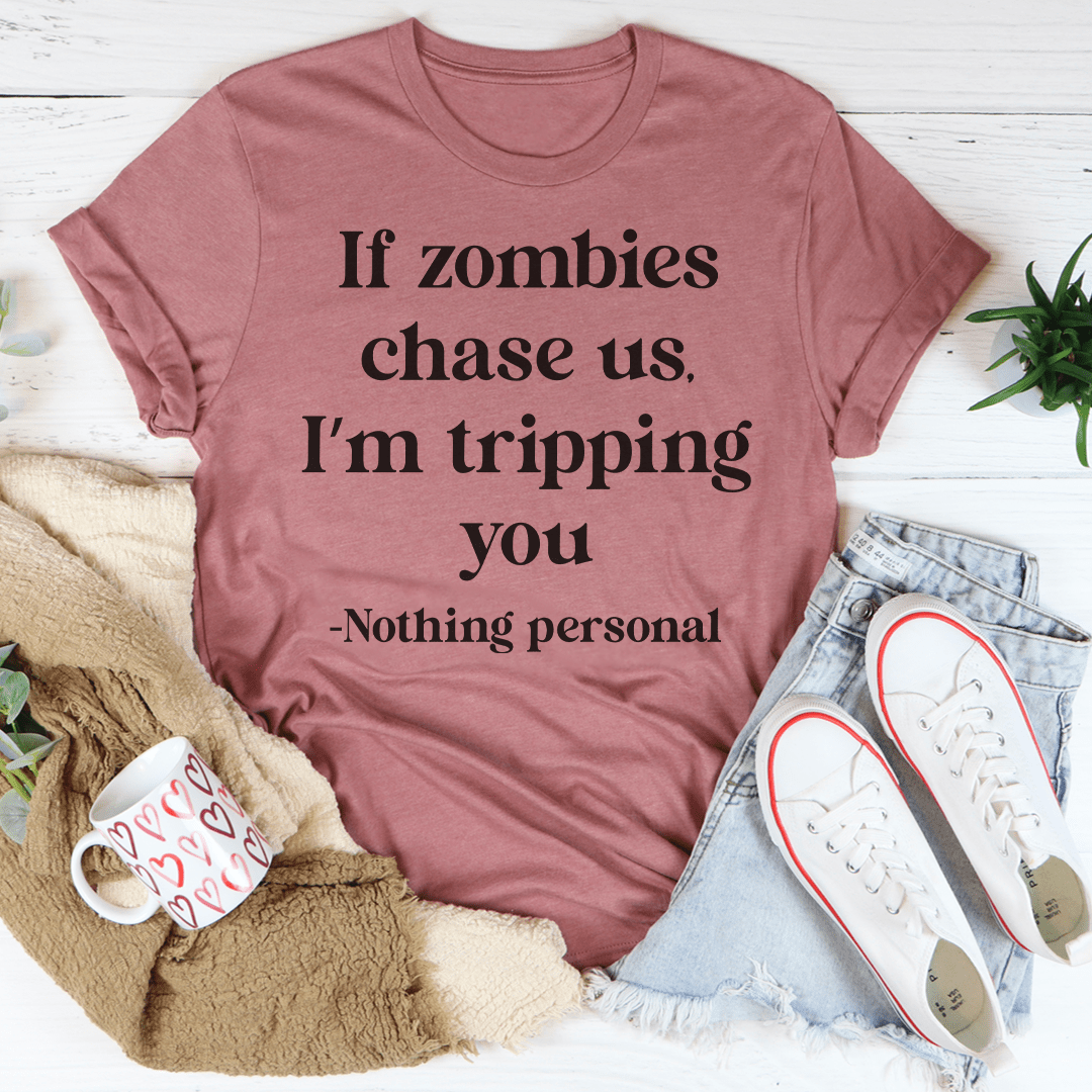 A humorous t-shirt featuring the phrase 'If Zombies Chase Us I'm Tripping You', made from soft cotton with double stitching.