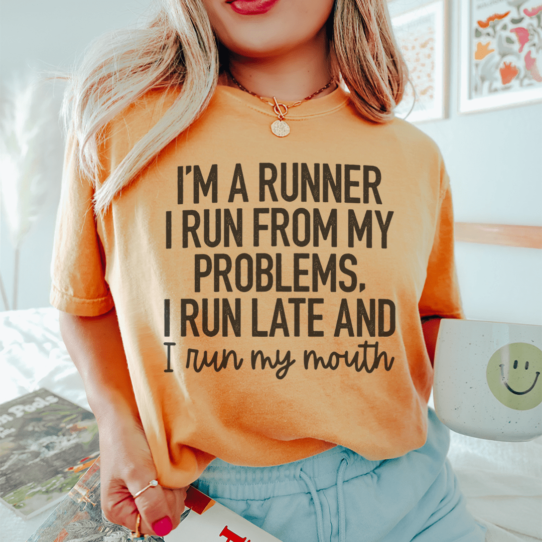 A humorous t-shirt featuring the phrase 'I'm A Runner I Run From My Problems, I Run Late And I Run My Mouth' in bold print, made from soft cotton.