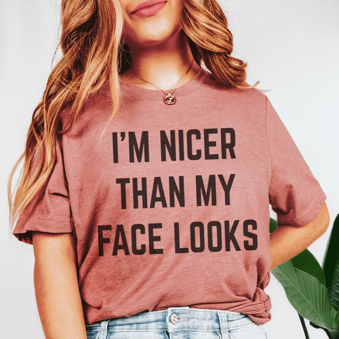 I'm Nicer Than My Face Looks Tee displayed on a hanger, showcasing its soft cotton fabric and humorous design.