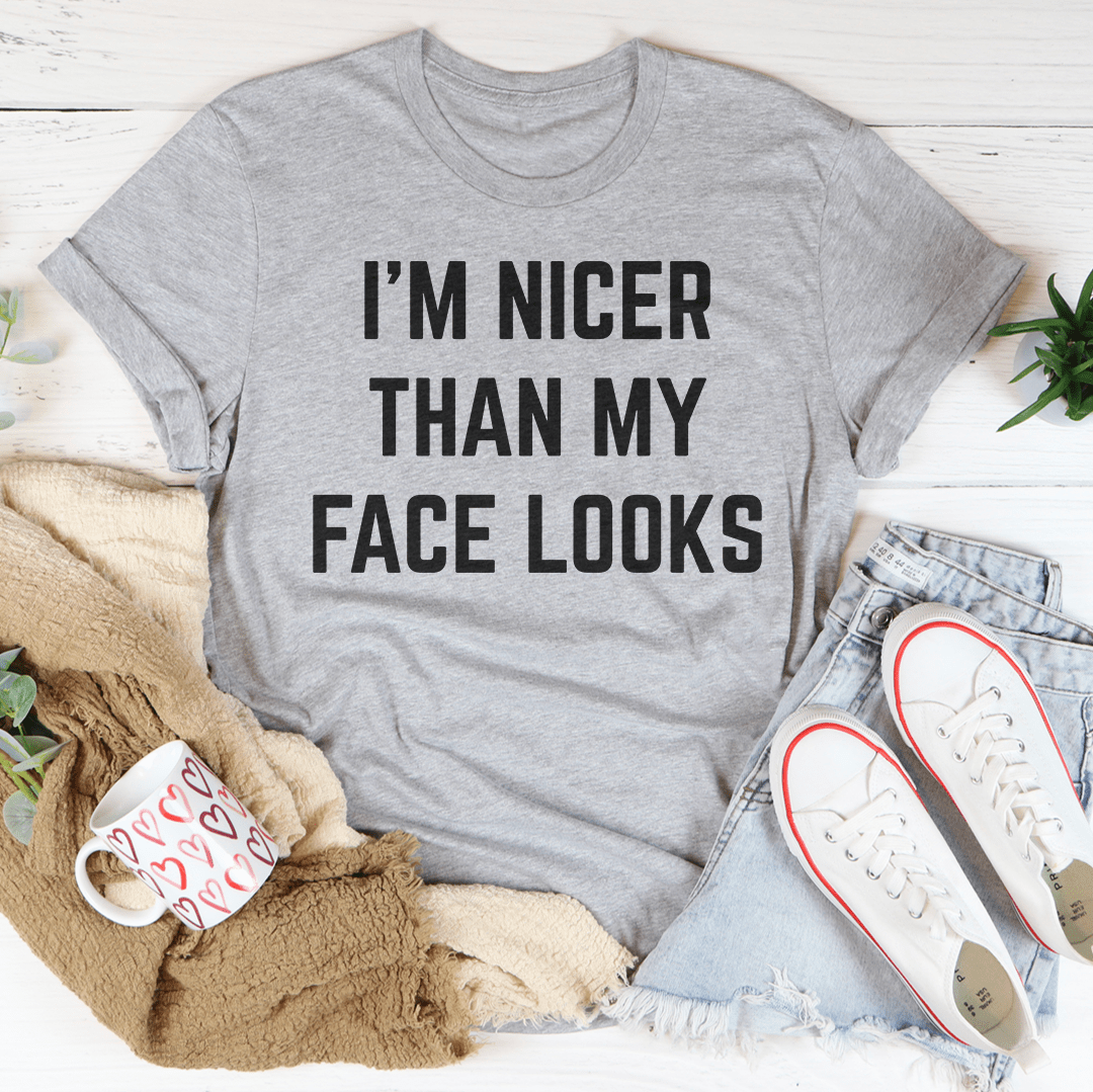 I'm Nicer Than My Face Looks Tee displayed on a hanger, showcasing its soft cotton fabric and humorous design.