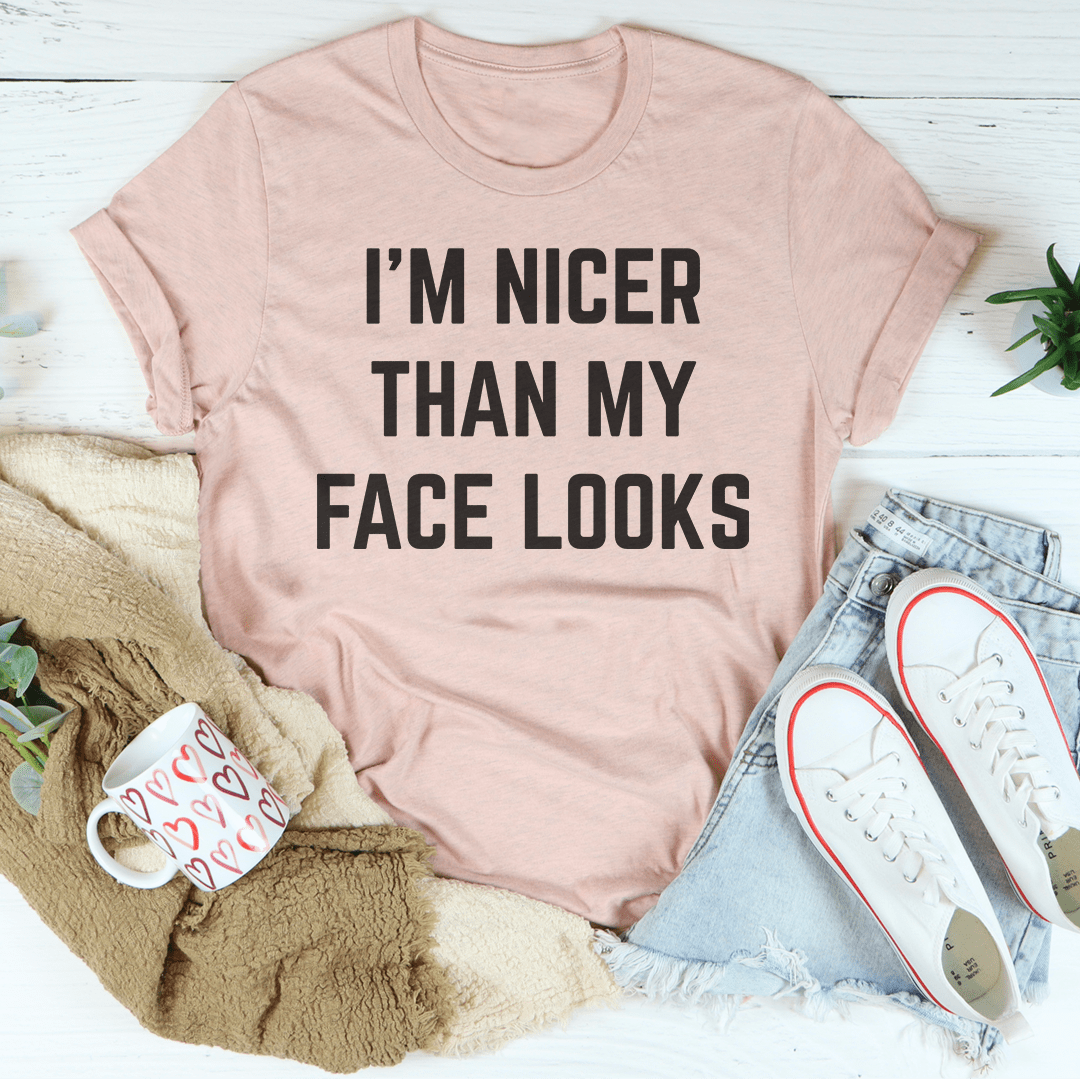 I'm Nicer Than My Face Looks Tee displayed on a hanger, showcasing its soft cotton fabric and humorous design.