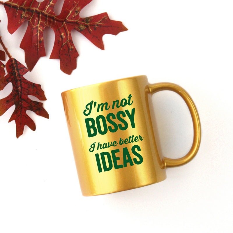 Ceramic mug with gold metallic coating featuring the phrase 'I'm Not Bossy, I Have Better Ideas' in stylish typography.