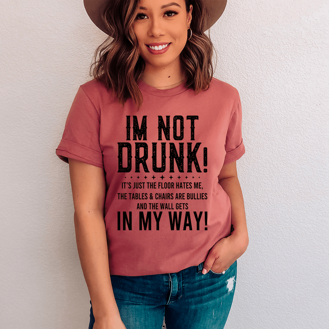 A black t-shirt with the text 'I'm Not Drunk' printed in bold white letters, showcasing a casual and humorous style.