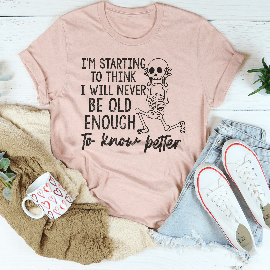 A stylish t-shirt featuring the phrase 'I'm Starting To Think I Will Never Be Old Enough To Know Better', made from soft cotton with durable stitching.