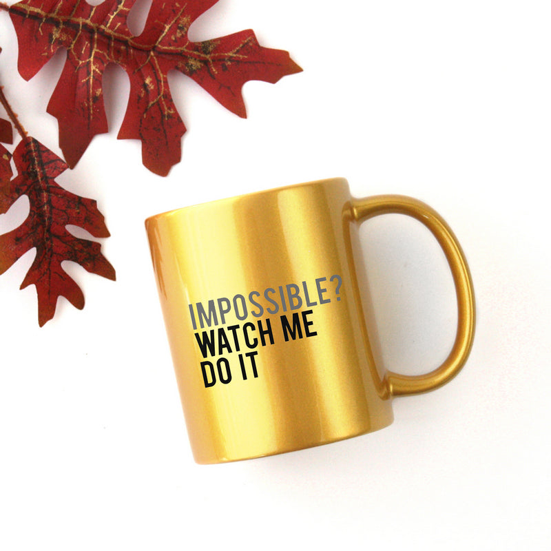 A stylish gold and silver ceramic mug with a unique design, perfect for coffee or tea.