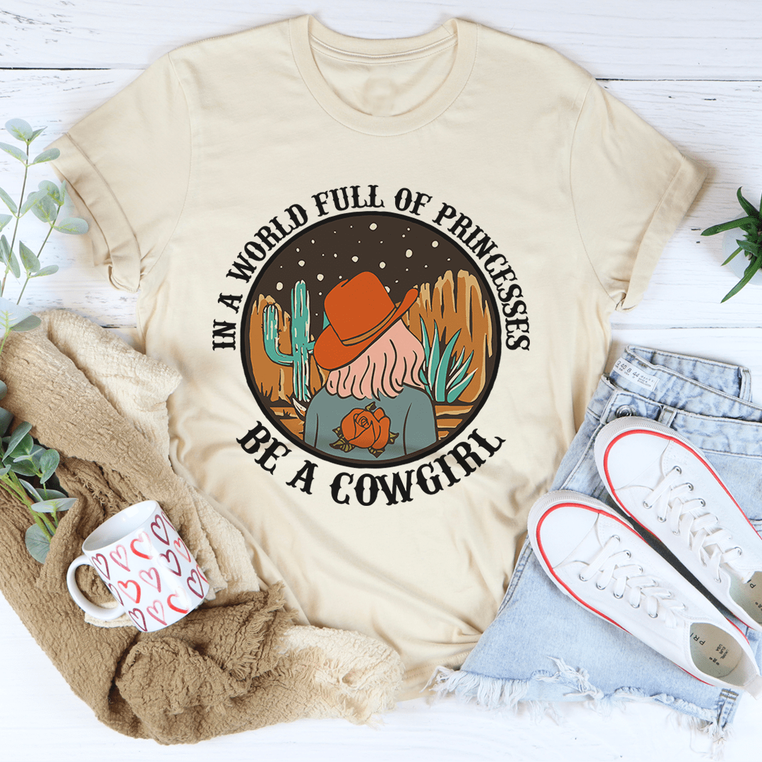 A stylish cowgirl-themed t-shirt featuring the phrase 'In A World Full Of Princesses Be A Cowgirl', made from soft cotton.