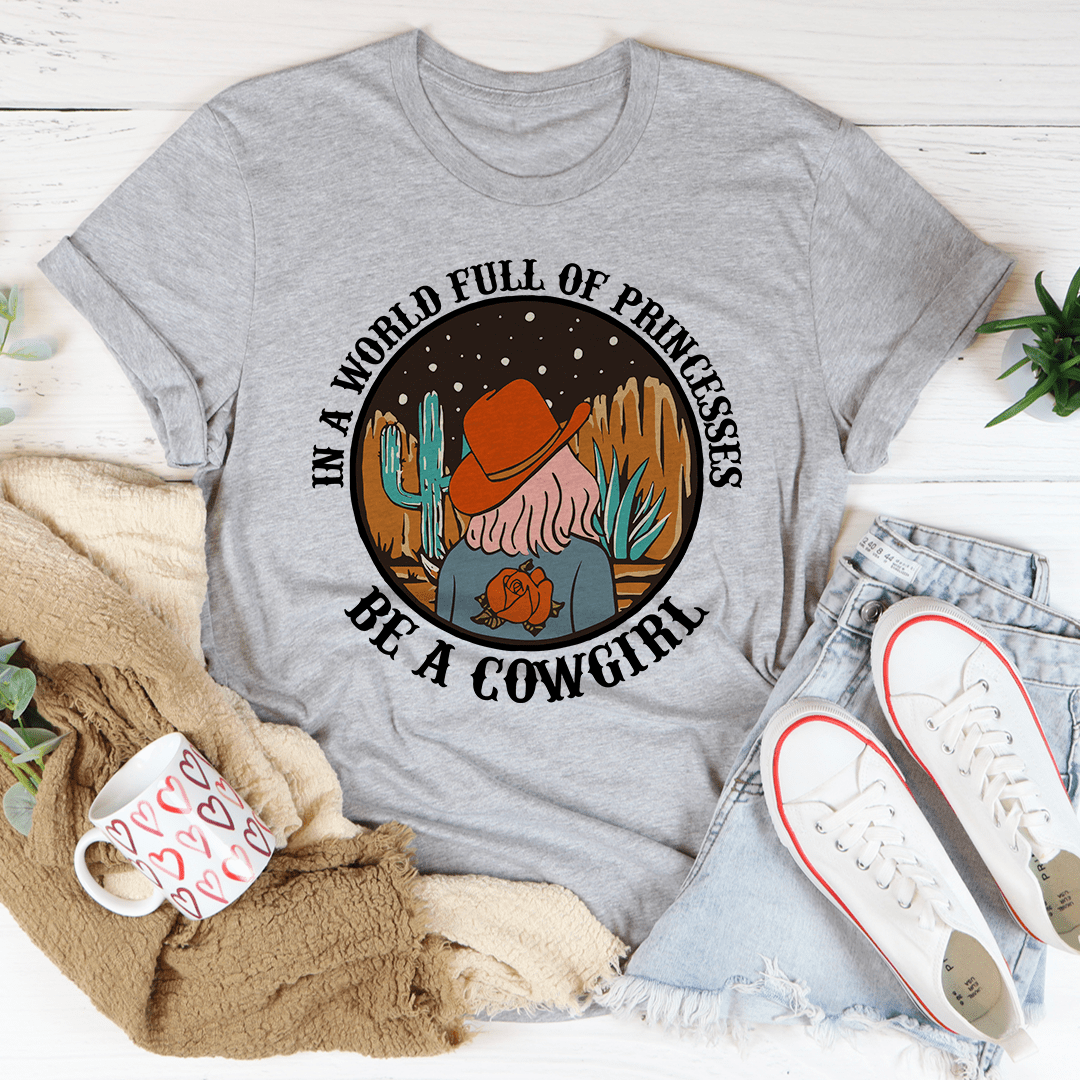 A stylish cowgirl-themed t-shirt featuring the phrase 'In A World Full Of Princesses Be A Cowgirl', made from soft cotton.