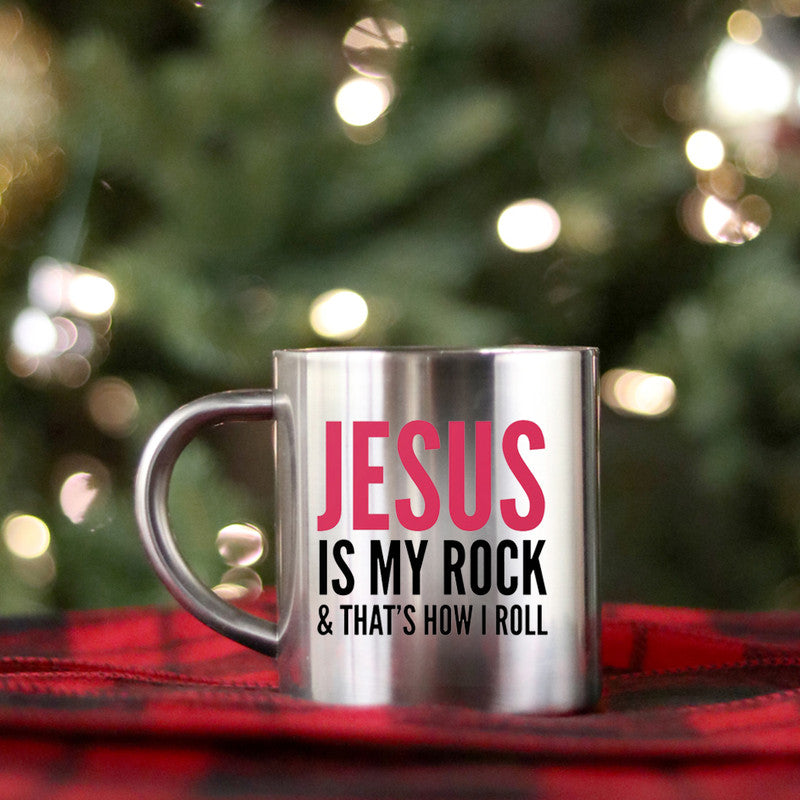 Ceramic mug with gold and silver design featuring 'Jesus Is My Rock That's How I Roll' text, perfect for beverages.