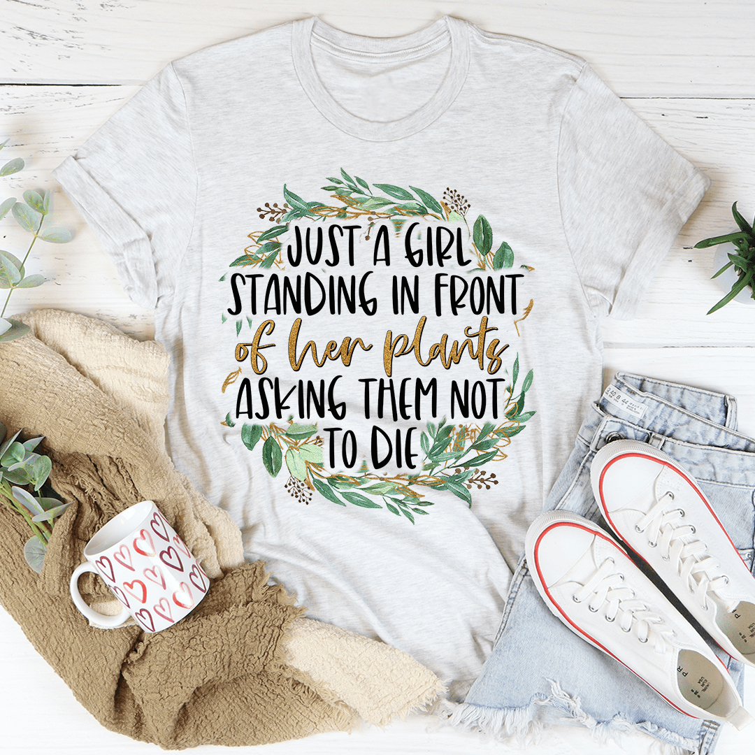 A stylish t-shirt featuring the phrase 'Just A Girl Standing In Front Of Her Plants', made from soft cotton with double stitching.