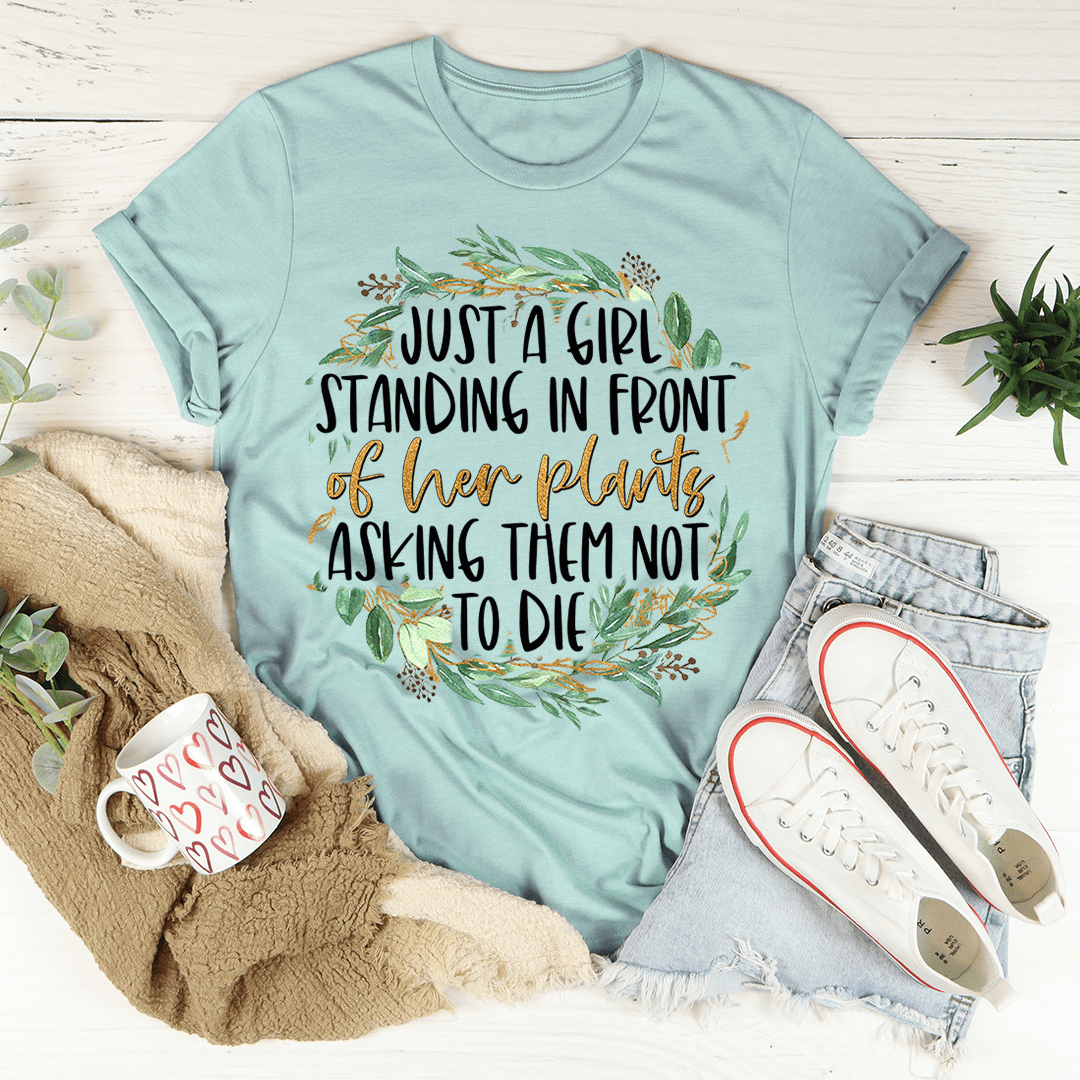 A stylish t-shirt featuring the phrase 'Just A Girl Standing In Front Of Her Plants', made from soft cotton with double stitching.