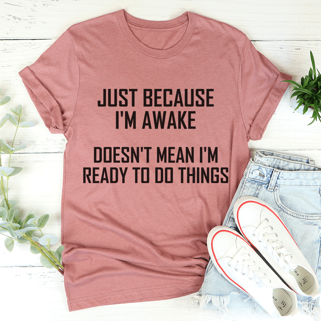 A comfortable and stylish t-shirt featuring the phrase 'Just Because I'm Awake Doesn't Mean I'm Ready To Do Things', made from soft ring-spun cotton.