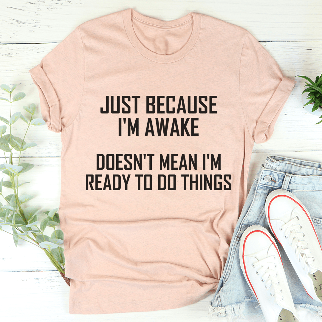 A comfortable and stylish t-shirt featuring the phrase 'Just Because I'm Awake Doesn't Mean I'm Ready To Do Things', made from soft ring-spun cotton.