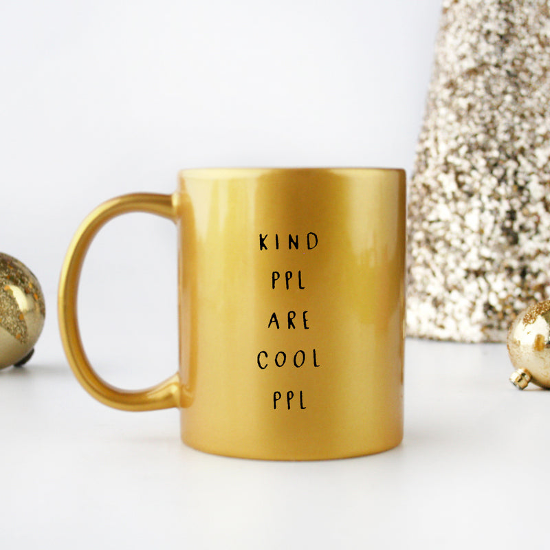 A stylish gold and silver ceramic mug with the phrase 'Kind People Are Cool People' elegantly displayed.