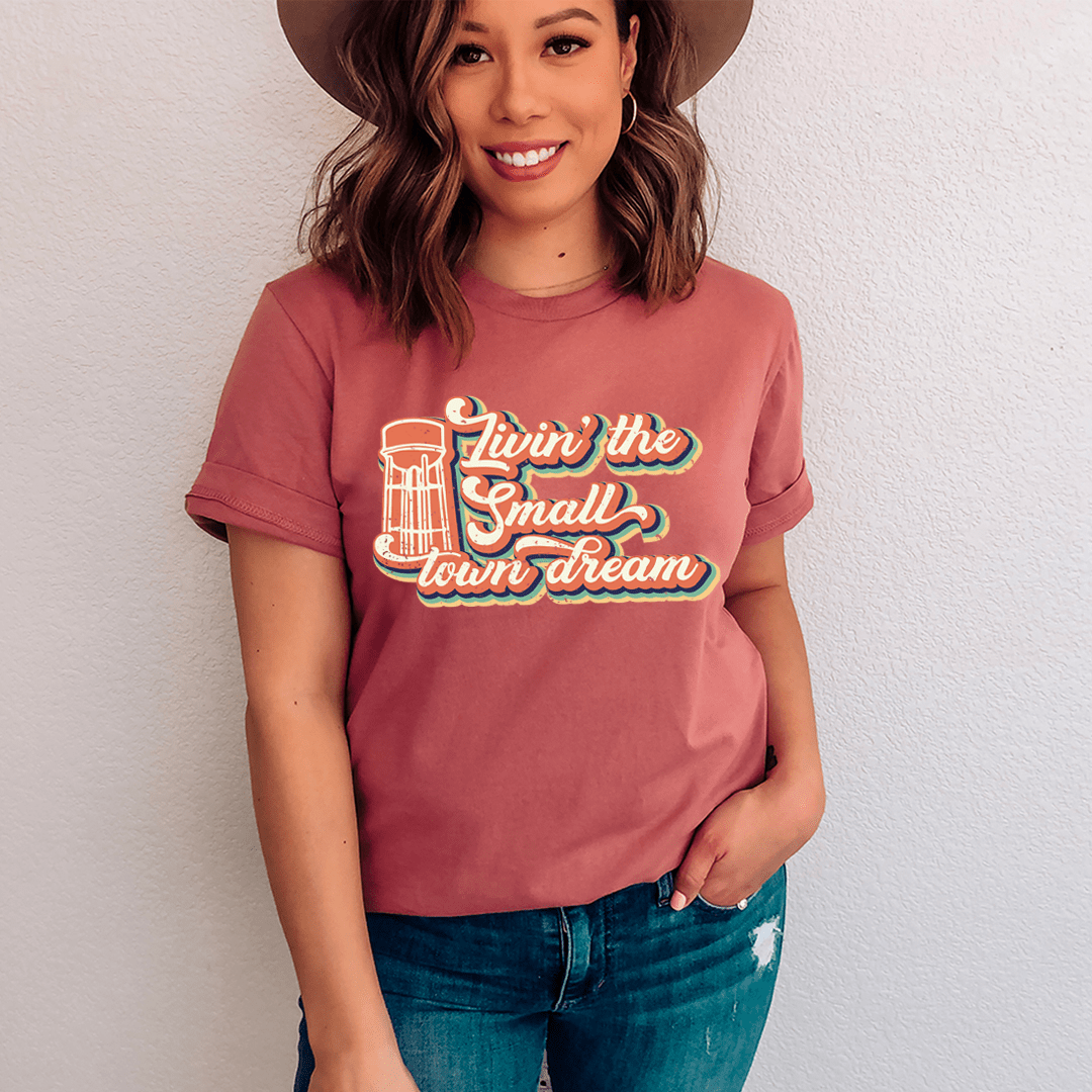 A comfortable and stylish Livin' The Small Town Dream Tee made from soft ring-spun cotton, featuring double stitching for durability.