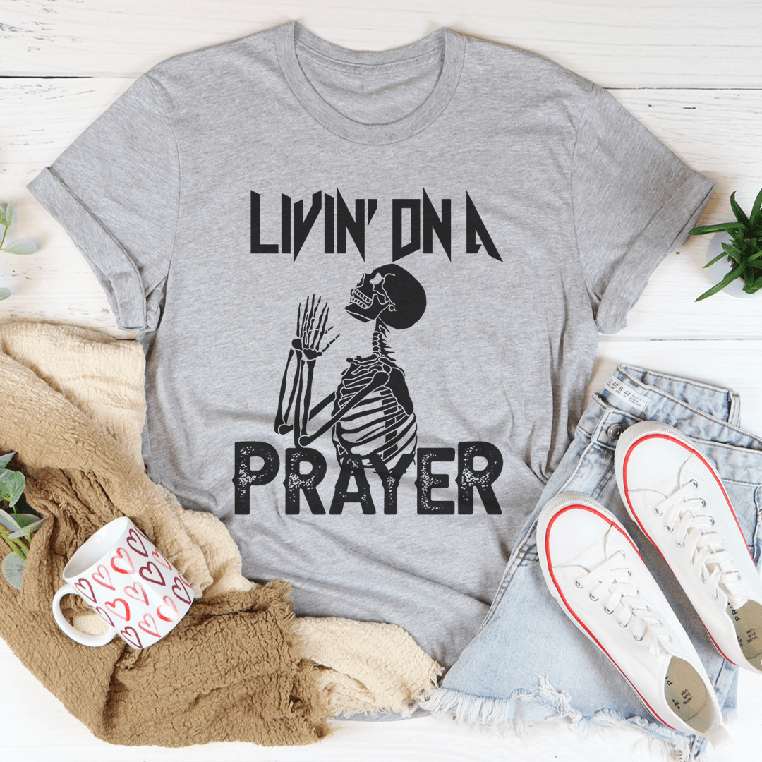 Living On A Prayer Skeleton Tee featuring a unique skeleton design on a soft cotton fabric.