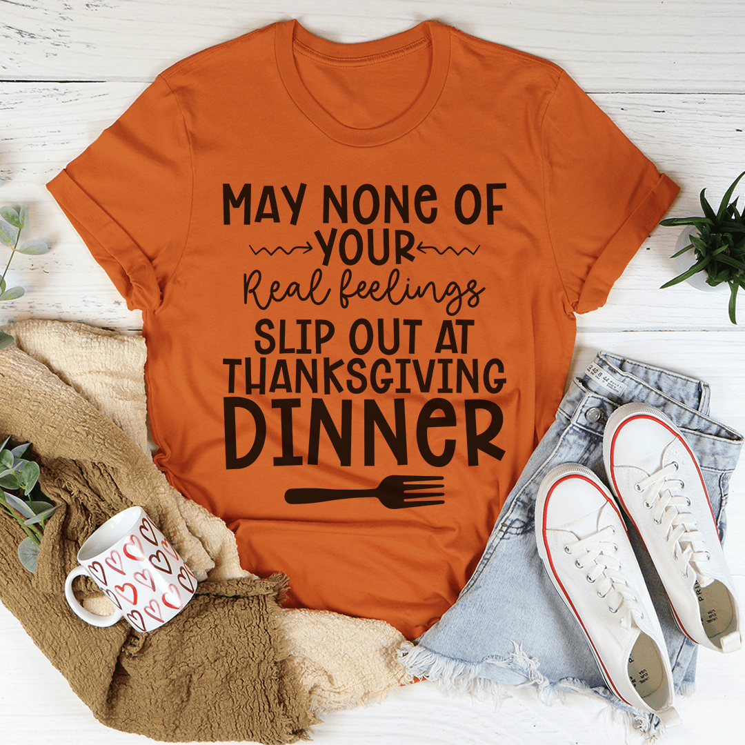 A humorous Thanksgiving T-Shirt featuring the phrase 'May None Of Your Real Feelings Slip Out At Thanksgiving Dinner', made from soft cotton.