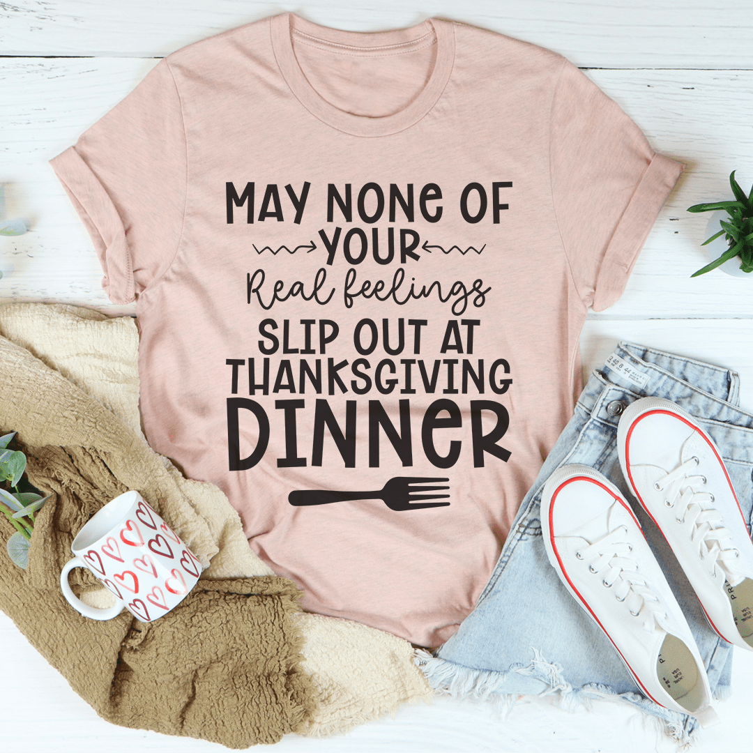 A humorous Thanksgiving T-Shirt featuring the phrase 'May None Of Your Real Feelings Slip Out At Thanksgiving Dinner', made from soft cotton.