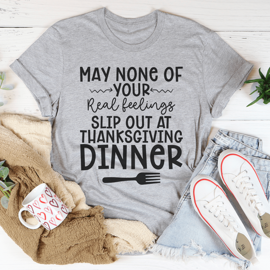 A humorous Thanksgiving T-Shirt featuring the phrase 'May None Of Your Real Feelings Slip Out At Thanksgiving Dinner', made from soft cotton.