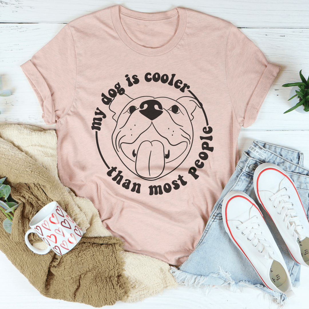 A stylish t-shirt featuring the phrase 'My Dog Is Cooler Than Most People' printed on it, made from soft cotton fabric.